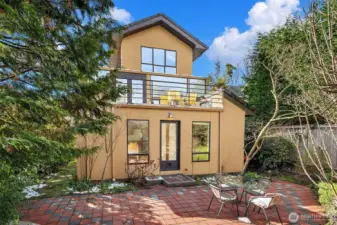 Architecturally striking rear elevation nestled into a private, landscaped setting