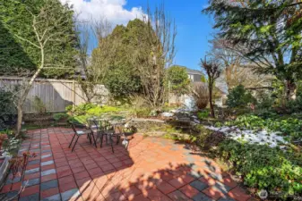 Multiple patios and lush garden spaces create seamless indoor-outdoor living