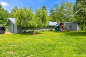 The shop offers additional covered parking and room for a workshop.  The garden tool shed is behind the playset.