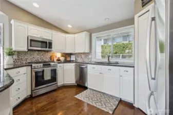 Microwave, gas stove and dishwasher all convey with the home. Sink area overlooks back yard and patio area.