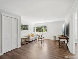 View of family room from just past the foyer, storage closet behind closed doors, bedroom #3 is just to the right in front of the television