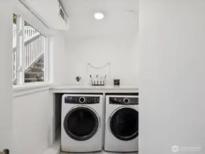 Gorgeous dedicated laundry room complete with folding shelf, Electrolux washer & dryer, room is full of natural light