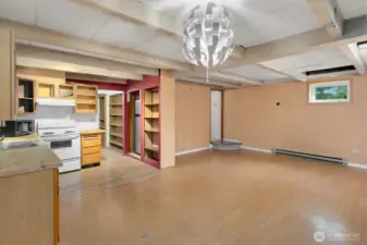 Another view of the lower level great room, showing the entry from the upstairs in the distance, and the second kitchen on the left side.