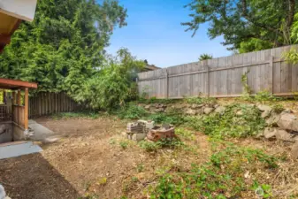 The fenced backyard is ready for your green thumb!