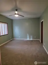 Large primary bedroom with a ceiling fan.