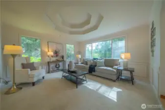 Elegant living room with coffered ceiling and peaceful views of nature!