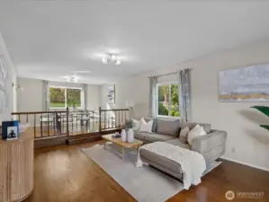 Light-filled sunken living room with hardwood floors and seamless connection to the dining area, creating an open and inviting main level.