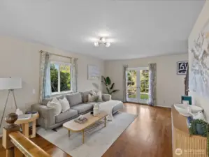 Bright and comfortable living room with views of the surrounding greenery and direct access to the outdoors.