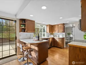 Functional kitchen with ample cabinetry, breakfast bar seating, and direct access to the outdoor patio.