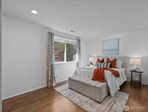 Bedroom featuring hardwood floors, natural light, and a clean, calming design.