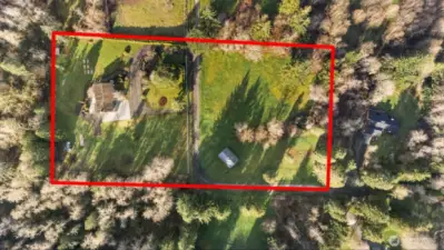 Aerial view of the 5-acre property showing open pasture, tree-lined boundaries, and overall layout
