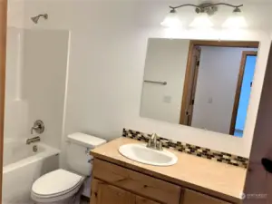 Full bathroom by back bedrooms