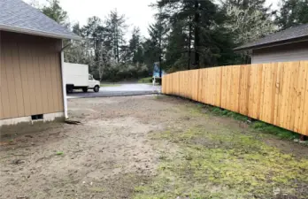 Side front corner of house showing long privacy fence