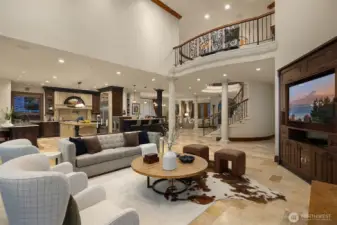 A striking balcony is upheld by concrete columns as it stretches along the upper level with a crafted wrought iron railing and graceful scrollwork. The architectural details in this home are refined and timeless.