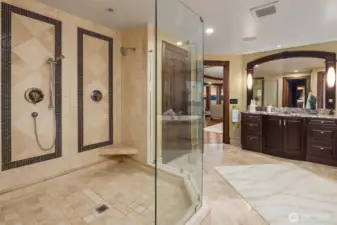 Oversized walk-in shower with custom tile inlay and three shower heads for a spa like luxurious experience.