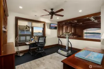 Exercise room overlooks the library with sound system zone, TV and an incredible view of the Puget Sound.