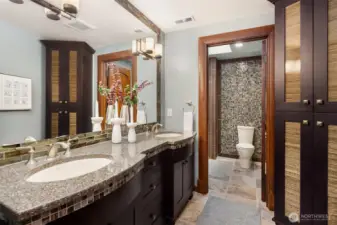 Upper-level bath offers a double sink solid surface vanity with complementing custom tile in shower and backsplash.