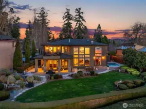 This backyard oasis resembles a resort with water features, firepit, custom paver patio, outdoor kitchen with all the bells and whistles, surrounded by english gardens.