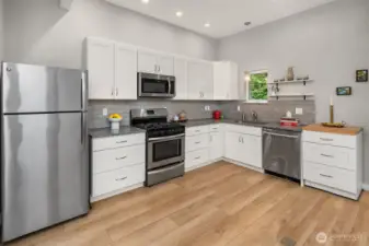Newly remodeled kitchen boasts, stainless steel appliances, a propane stove for cooking with flame and marble counters.