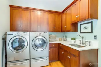 This amazing laundry room is also just off the kitchen/desk/ family room.  Great full sized washer & dryer, lots of cabinets for cleaning supplies, etc. and counter for folding and cleaning.  This room also just got upgraded to quartz counters and an extra large new sink!