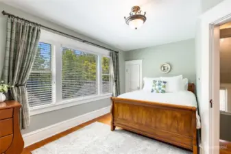 The second upstairs bedroom is great for a Queen bed and enjoys a large window that looks out over the front gardens.