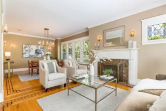 The formal living room makes a beautiful first impression- spacious and warm, with the original fireplace, hardwoods with mahogany ribbon inlay, crown molding and diamond windows.  All of the lighting has been recently replaced with glowing RH wall sconces and chandelier.