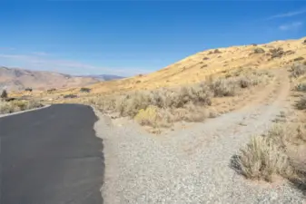 Looking North from the maintained, paved road. Driveway to the property is on the right.