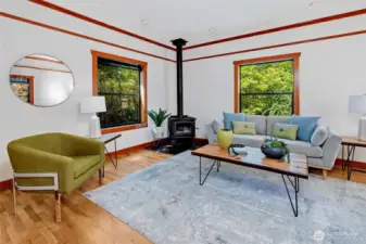 So much natural light cascades in from lovely windows, looking out into the green-scape, making you feel like your up in the treetops. Notice the wood burning stove which heats the whole upstairs on a winters day.