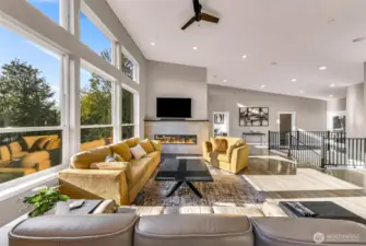 Open concept living room flooded with light and custom LED colored lit fire place