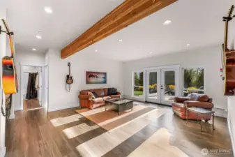 Light flooded down stairs rec room with wet bar and double doors out to fire pit and waterfalls