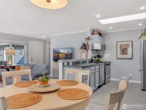 Living room, dining room, and kitchen. The main entry and hallway to the bedrooms are in the back.
