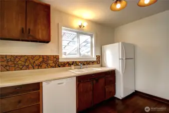 An ample kitchen with a new dishwasher and refrigerator.