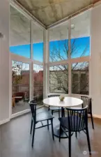 Warm western light pours through the floor-to-ceiling windows, complemented by a private deck with tree-lined and Space Needle views.