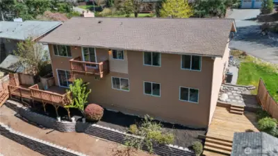 Backyard deck is perfect for entertaining, enveloped by a beautiful green space!
