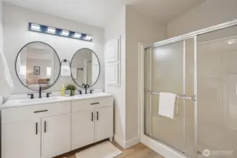 Primary bathroom with new double vanity with quartz countertop, and new light fixtures.