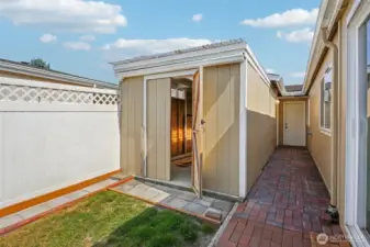 The side view of the house shows a brick hallway with two sheds on the left. The door at the back leads to the garage.