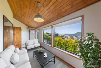 Enclosed sunroom with warm, wood ceilings to relax and enjoy the gorgeous views.