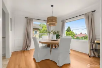 Formal dining room off kitchen with hardwood floors & designer lighting