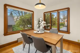 Dining room framed by large windows.