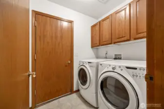 Utility room with cabinets - washer and dryer are included. Closed door on the left goes out to garage.