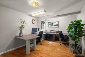 The lower-level remote office boasts a wraparound desk designed to accommodate several individuals working simultaneously—ideal for a home business or collaborative workspace.
