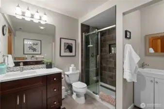 The lower level 3/4 bathroom has been tastefully updated with a frameless glass shower door, floor to ceiling tiling and a quartz counter vanity with plenty of shelving.