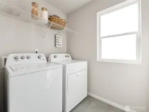 Light-filled upstairs laundry features Whirlpool washer and dryer, durable flooring, and a full-length wire shelf to keep supplies tidy. Pictures are for representational purposes only, colors and features may vary.
