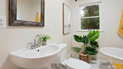 The second main-level bathroom impresses with gorgeous tilework, a sleek low-profile sink, and a deep soaking tub that invites you to unwind in style.