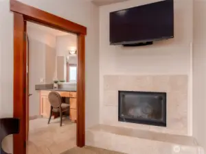 View of the main level Primary Bedroom Suite  fireplace looking towards the spa-like bath w/ vanity area and Jacuzzi tub.