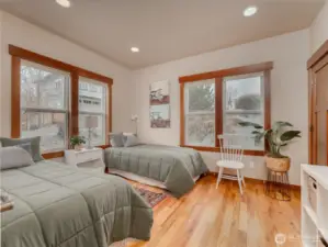 View of main level guest bedroom w/ hardwood floors, oversized windows and large closet.