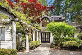 Mature wisteria frames the entryway trellis offering a sense of arrival and presence.