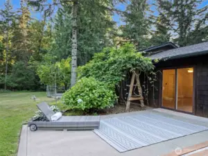 Patio off the detached office/storage building leading out to the large back yard