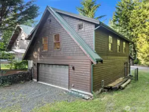 Back side of the 4 car tandem garage with dog kennel, storage racks, work bench and front & back garage doors