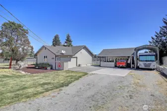 attached 2 car garage, carport that fits 2 cars + bonus rooms for shop and storage, additional storage in upper part of carport + RV covered parking